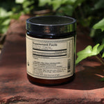 The Reishi Spirit Super Tonic - Fountain of Youth 4oz Powder on a rusty red surface surrounded by green ivy.