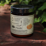 The side of the Cordyceps Energy Super Tonic Mushroom Powder on a red surface next to greenery.