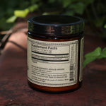 The Ashwagandha Nature's Chill Pill 4 oz Powder on a rusty red surface surrounded by ivy.