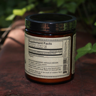 The Ashwagandha Nature's Chill Pill 4 oz Powder on a rusty red surface surrounded by ivy.