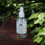 The Palo Santo Protection Mist - Auric Purification on a rusty red surface next to ivy.