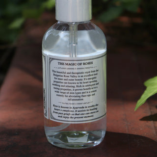 The side of the Rose Water Beauty Mist - Soothing Face Toner on a rusty red surface next to ivy.