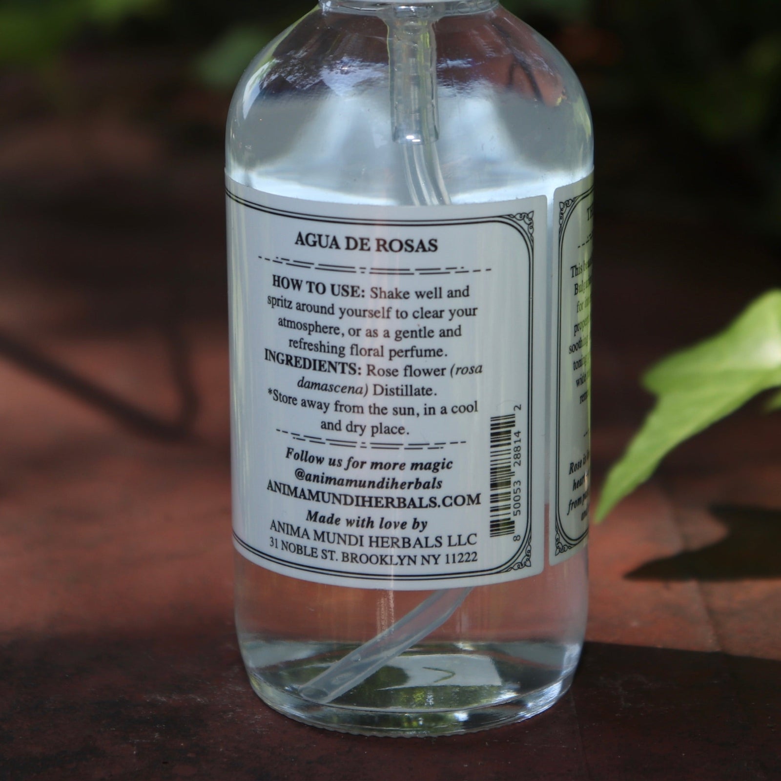 The back of the Rose Water Beauty Mist - Soothing Face Toner on a rusty red surface next to ivy.