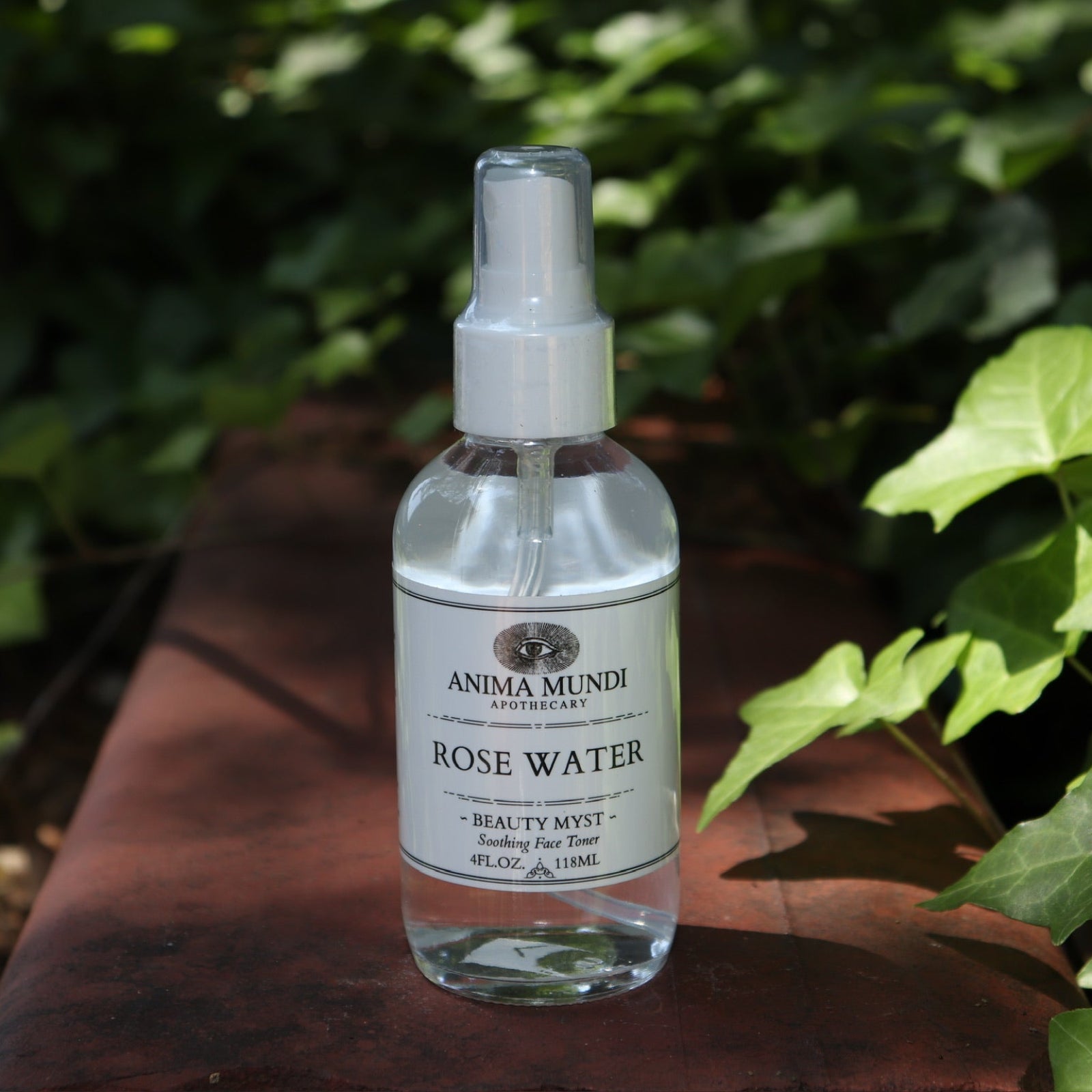 The Rose Water Beauty Mist - Soothing Face Toner on a rusty red surface next to ivy.