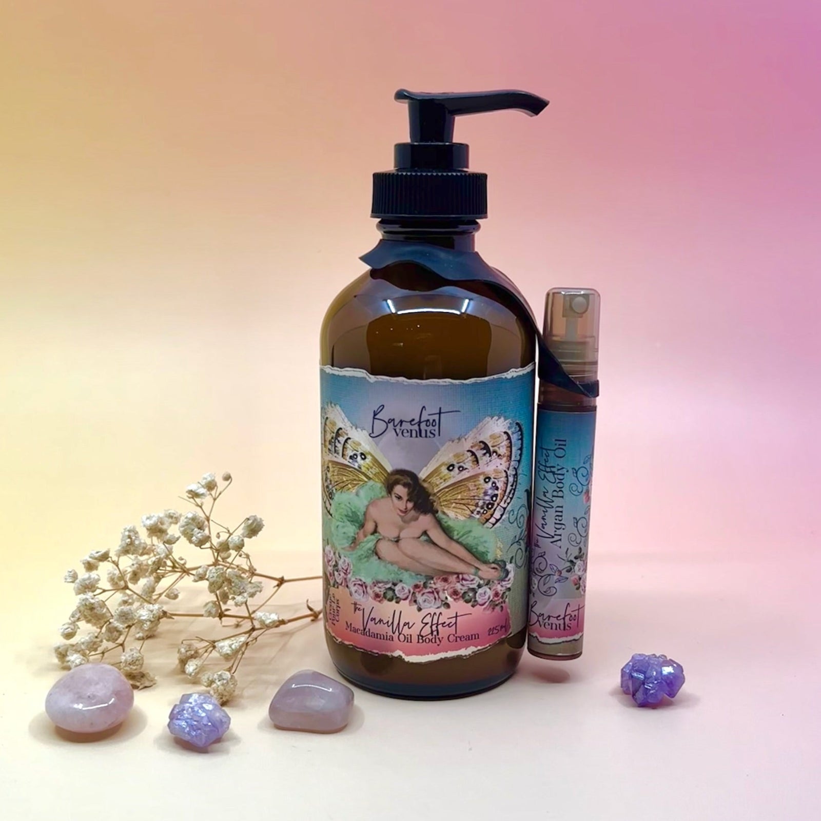 The The Vanilla Effect Body Cream Moisturizer surrounded by crystals and a dried flower on a light pink background.