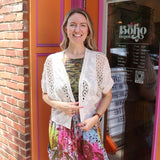 A woman wearing the beige Lace Open Front Cardigan with Batwing Sleeves with tie-dye bottoms and top.