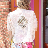 A woman wearing the beige Lace Open Front Cardigan with Batwing Sleeves with tie-dye bottoms and top.