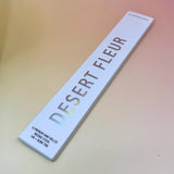 The Desert Fleur Incense by Bohemian Rêves on a pink and yellow background.