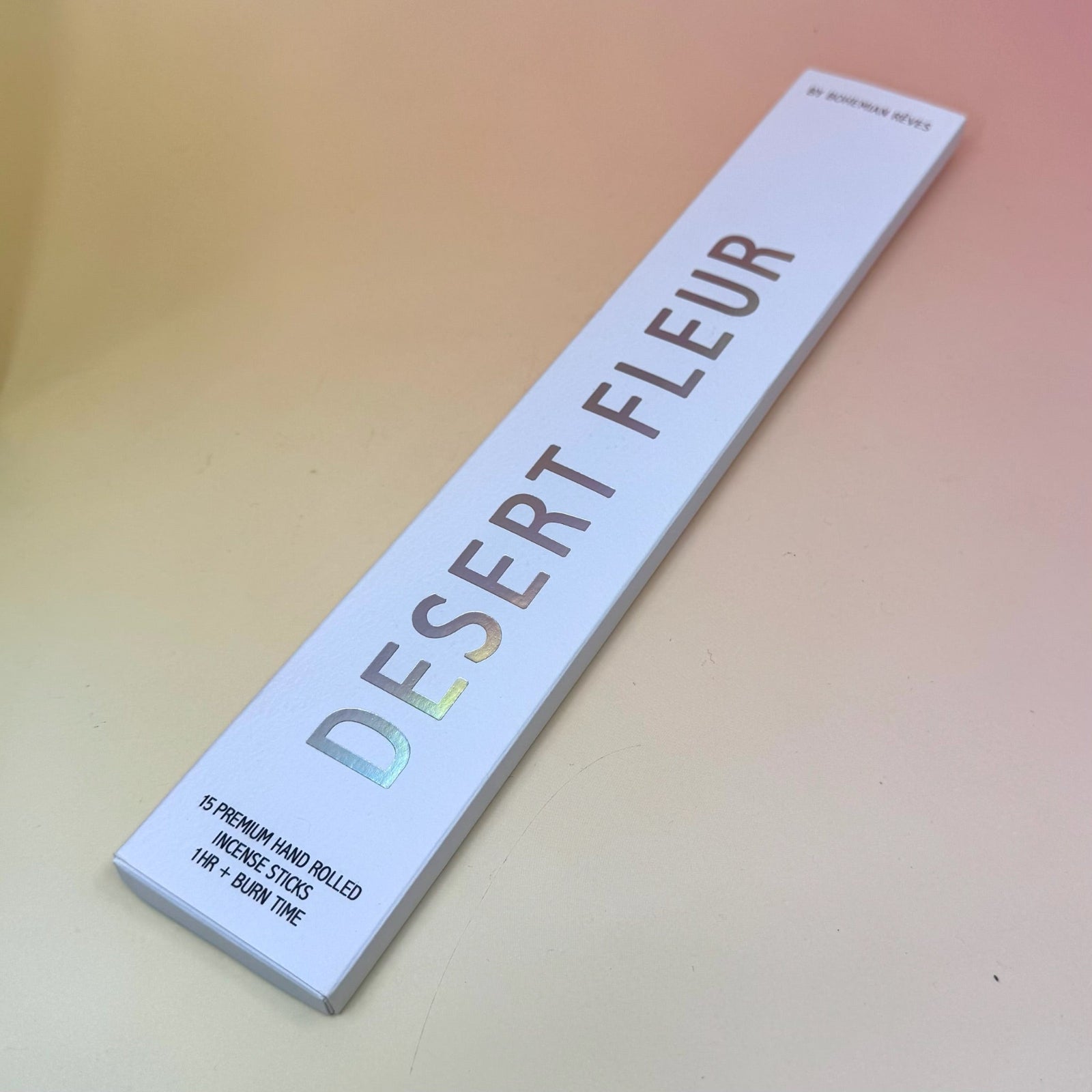 The Desert Fleur Incense by Bohemian Rêves on a pink and yellow background.