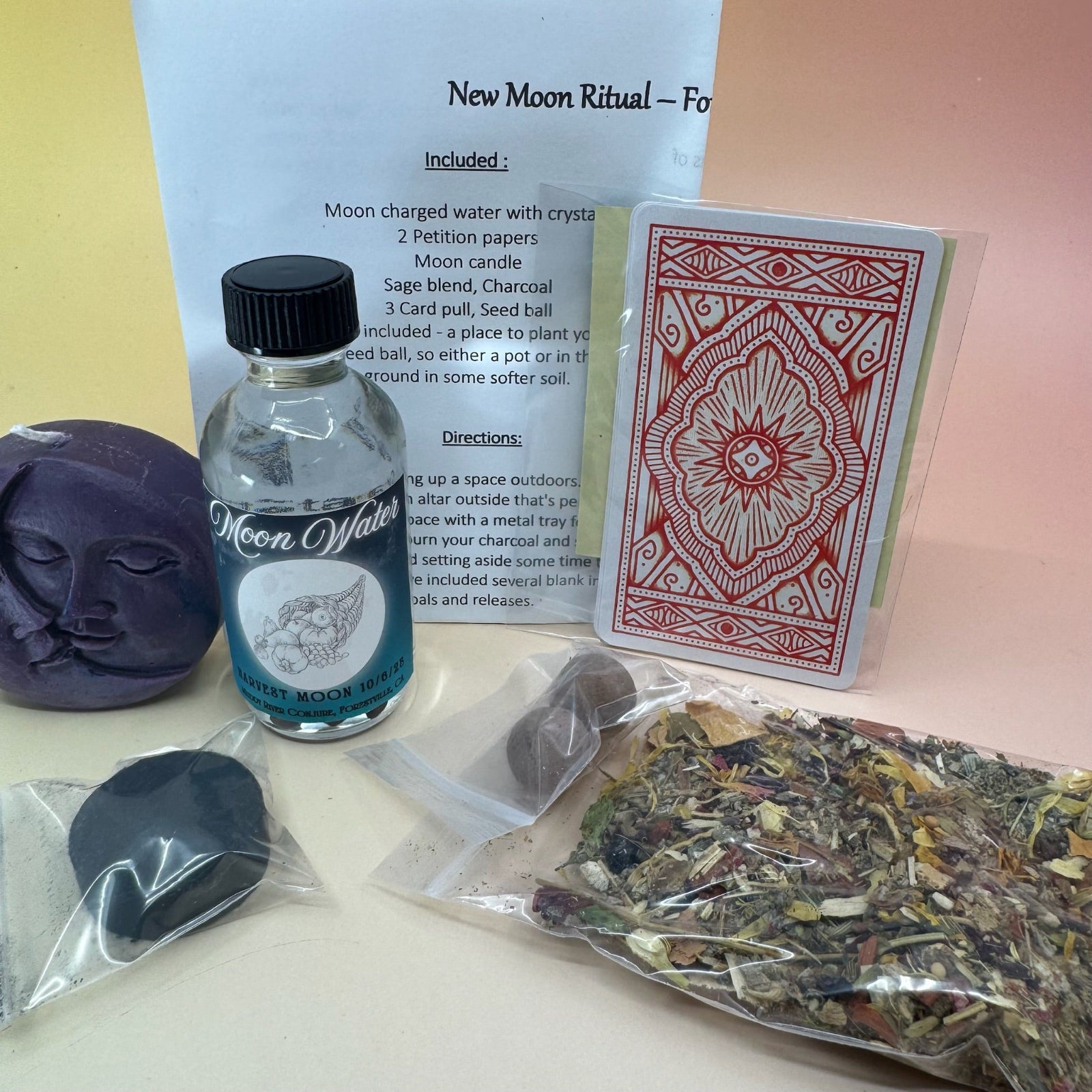 The contents of the New Moon Ritual Kit  on a pink and yellow background.