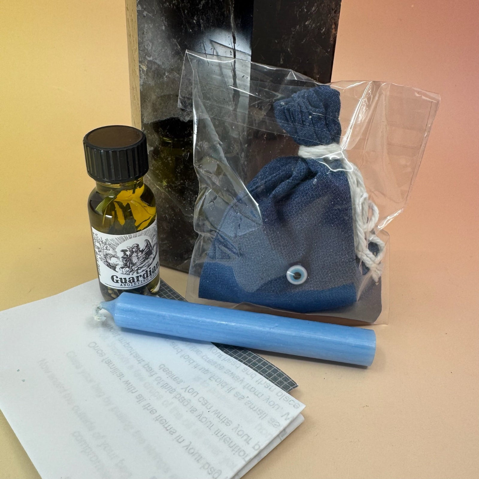 The contents of the protection Prayer Mojo Witchy Spell Bag against a crystal tower on a pink and yellow background.