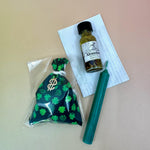 The contents of the money luck Prayer Mojo Witchy Spell Bag on a pink and yellow background.