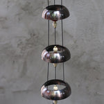 An up-close image of the Encore Copper Temple Bells in front of a white concrete wall.