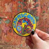 Someone holding the Capricorn Astral Weekend Zodiac Magnet 3" Round in front of a wooden background.