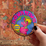 Someone holding the Aquarius Astral Weekend Zodiac Magnet 3" Round in front of a wooden background.