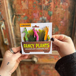 Someone holding the Wind Dancers Fancy Plants Diorama Kit  in front of a wooden background.