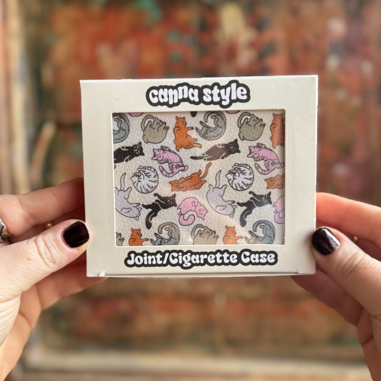 Someone holding the Cozy Cat Hardcover Cigarette Case in front of a wooden background.