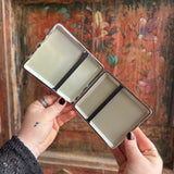 Someone holding the Cozy Cat Hardcover Cigarette Case in front of a wooden background, showing off the inside.