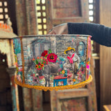 Someone holding the Cowgirl Collage Lamp Shade in front of a wooden background.