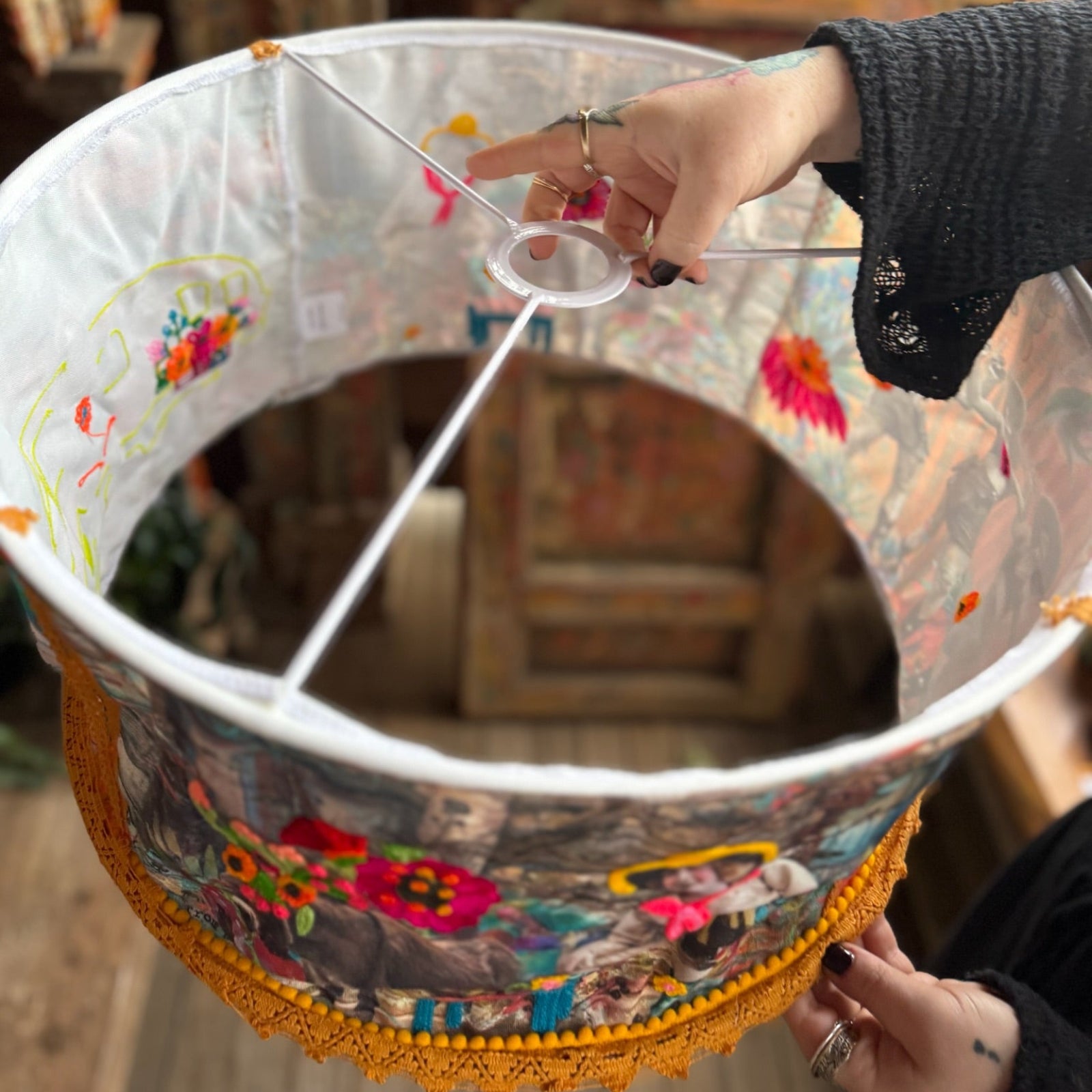 Someone holding the Cowgirl Collage Lamp Shade in front of a wooden background.