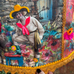 An up-close image of someone holding the Cowgirl Collage Lamp Shade in front of a wooden background.