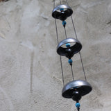 Someone holding the Turquoise Woodstock Temple Bells in front of a white wall.