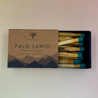 The Palo Santo Matchsticks on a pale pink and yellow background.