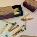 Three Palo Santo Matchstick boxes on a pale pink and yellow background.