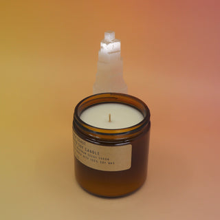 The Golden Coast - 12.5 oz Large Concentrated Soy Wax Candle in front of a selenite tower all on a pink and yellow background.
