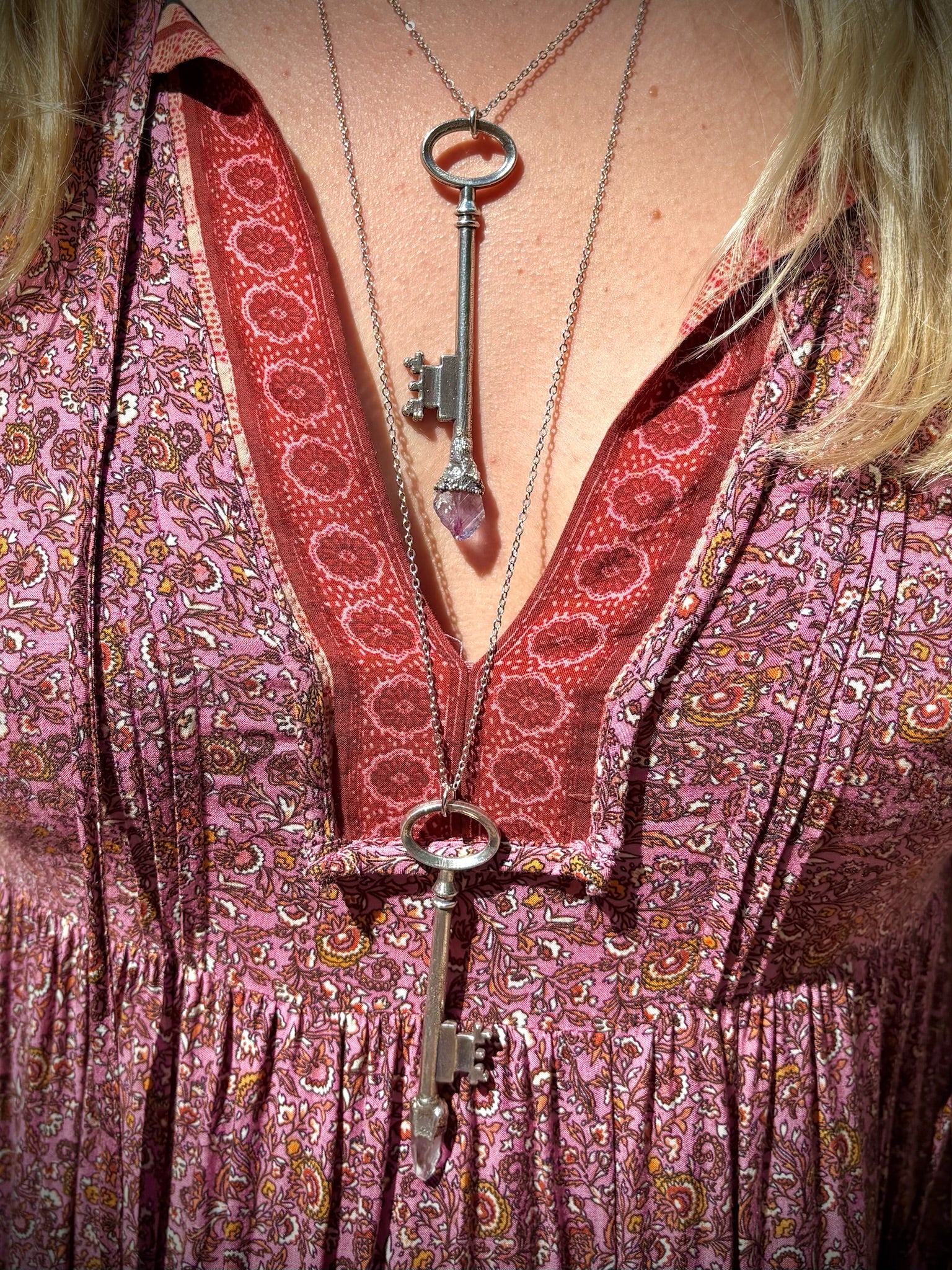 Someone wearing the Raw Amethyst and clear quartz Crystal Necklaces Vintage Skeleton Key in Silver.