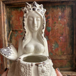 Someone holding the Goddess Mermaid & Urchin Planter in front of a wood background.