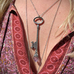 Someone wearing the Raw Amethyst Crystal Necklace Vintage Skeleton Key in Silver.