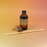 The P.F. Candle Co. Golden Coast - 3.5 oz Reed Diffuser on a pink and yellow background.