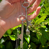 Someone holding the Raw Amethyst and Clear Quartz Crystal Vintage Skeleton Key Necklaces in Silver.