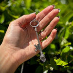 Someone holding the Raw Amethyst and Clear Quartz Crystal Vintage Skeleton Key Necklaces in Silver.