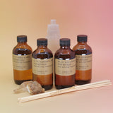 The P.F. Candle Co. Reed Diffusers in front of a selenite tower on a pink and yellow background.