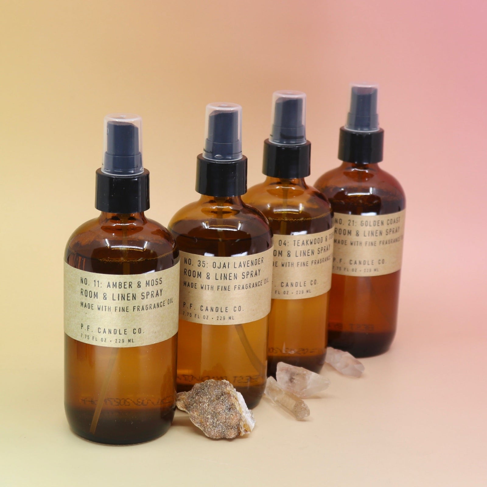 The P.F. Candle Co room & linen sprays on a pink and yellow background.