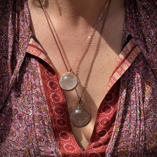 Someone wearing the Crystal Ball Necklace in Copper - Clear Quartz.