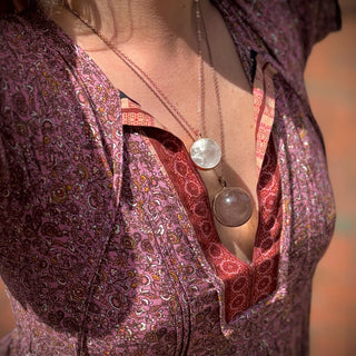 Someone wearing the Crystal Ball Necklace in Copper - Clear Quartz.