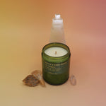 The P.F. Candle Co. - Vanilla & Ghost Pepper Candle in front of a selenite tower on a pink and yellow background.