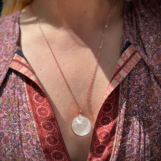 Someone wearing the Crystal Ball Necklace in Copper - Clear Quartz.
