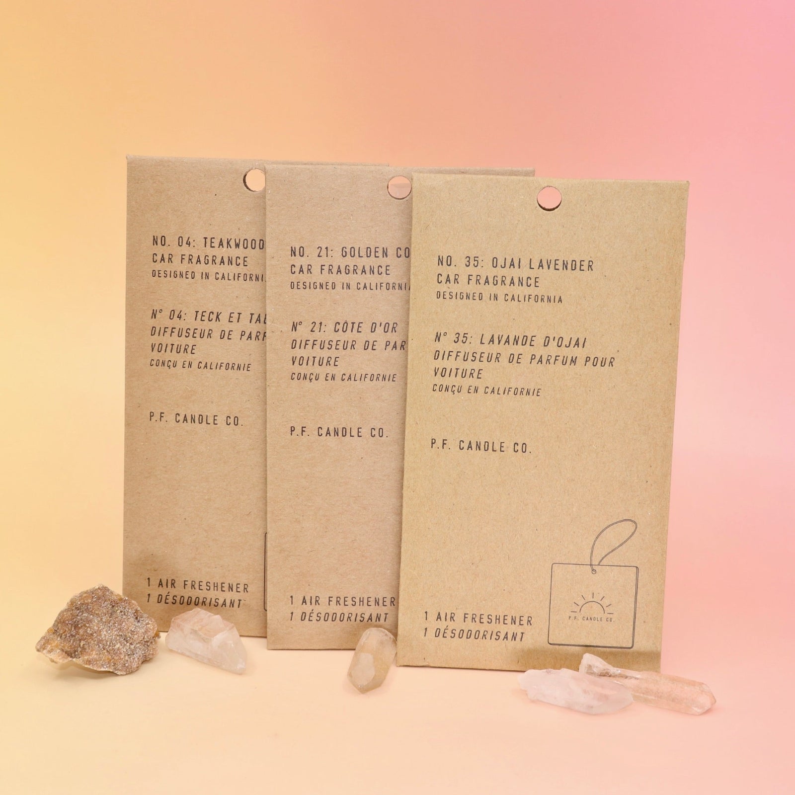 All three of the P.F. Candle Co. car fragrances on a pink and yellow background.