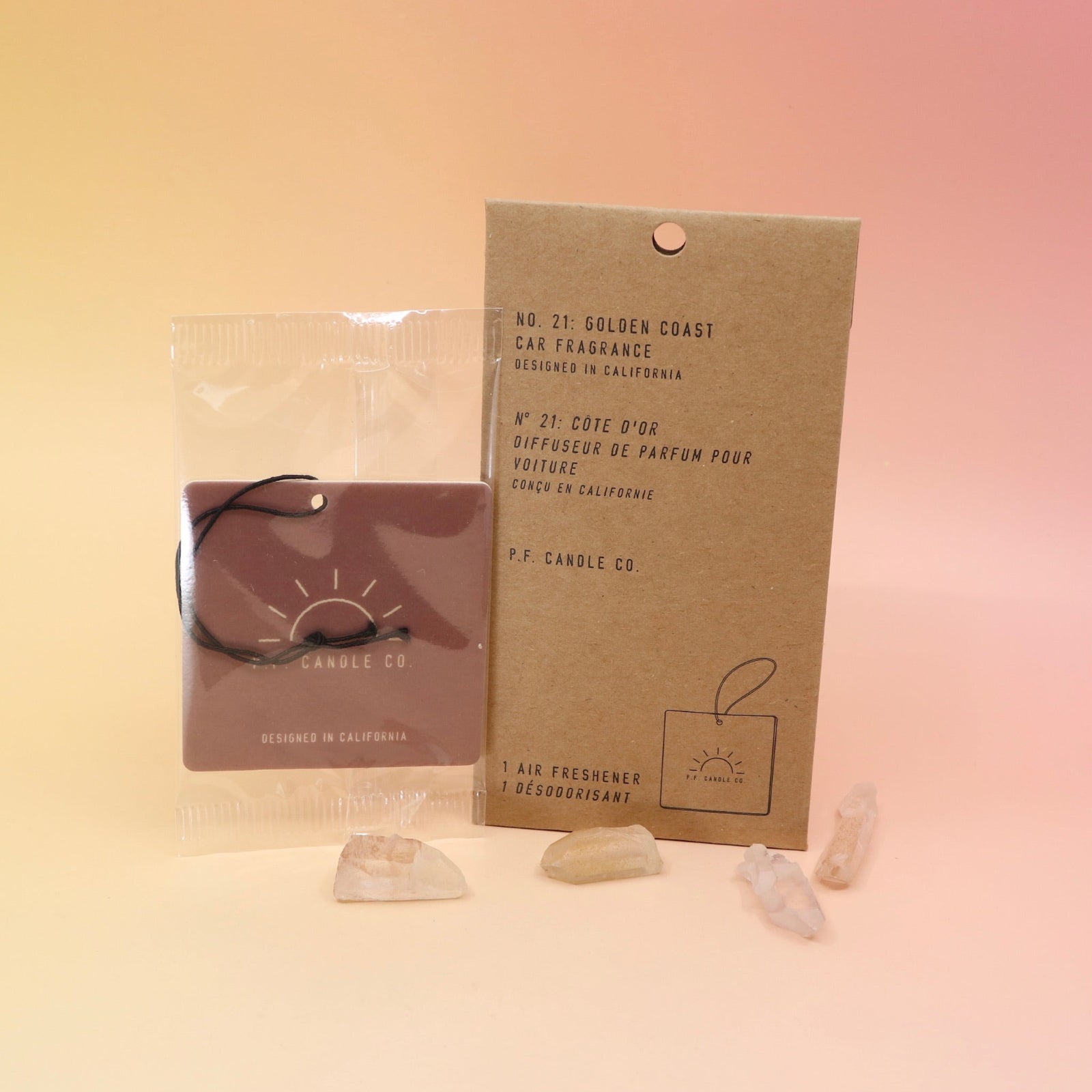 The P.F. Candle Co. Golden Coast - Car Fragrance on a pink and yellow background.