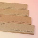 All four P.F. Candle Co. incense (Amber & Moss, golden Coast, Teakwood & Tobacco, and Ojai Lavender) on a pink and yellow background.
