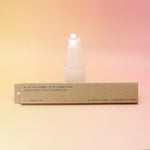 The P.F. Candle Co. Ojai Lavender - Incense in front of a selenite tower all on a pink and yellow background.