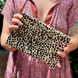 Someone holding the Tiny Spotted Hair on Hide Envelope Pouch Clutch.