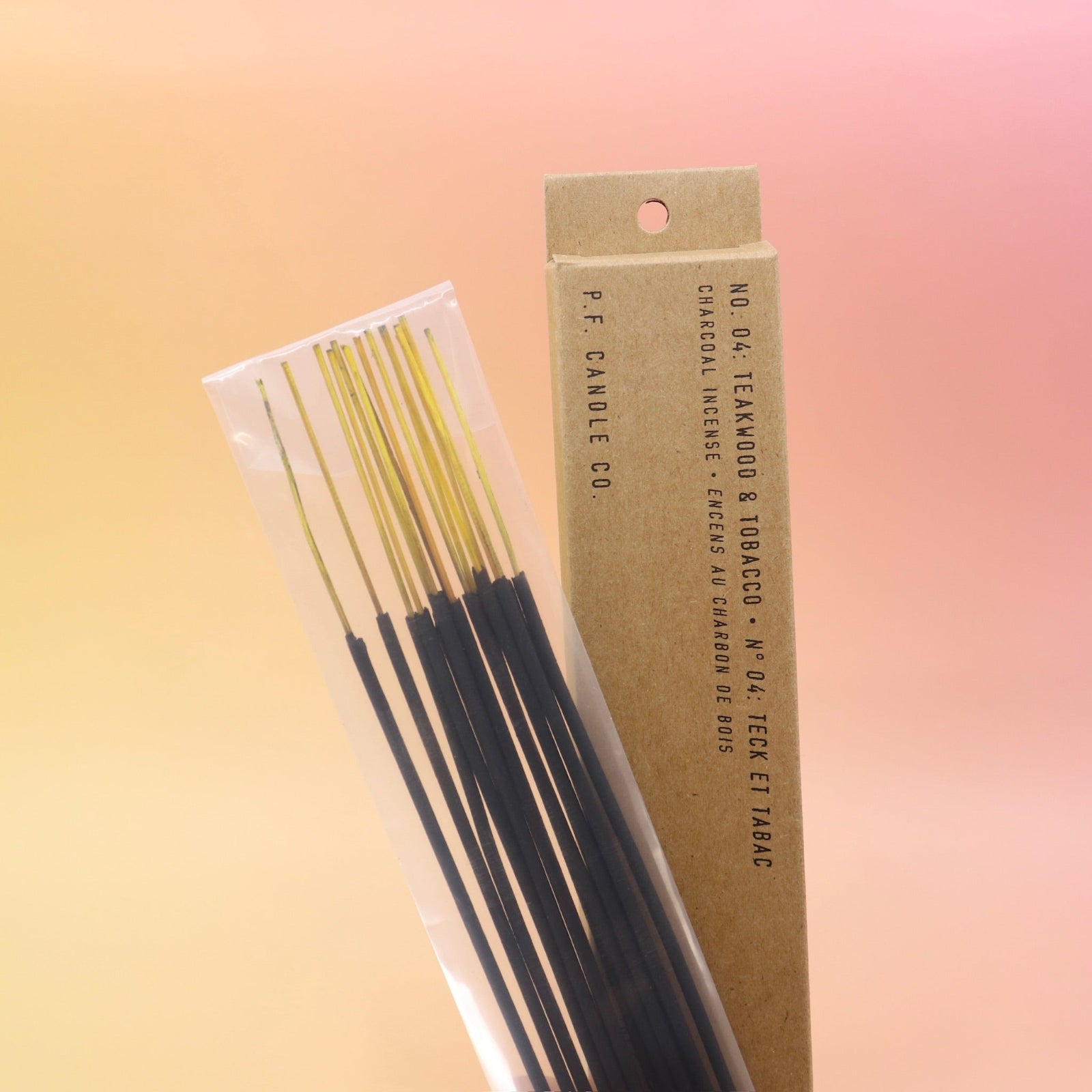 The P.F. Candle Co. Teakwood & Tobacco Incense on a pink and yellow background.