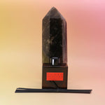 The Plush Vetiver - HI-FI Reed Diffuser in front of a crystal tower on a pink and yellow background.