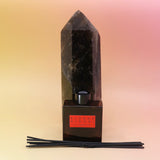 The Blonde Hinoki – HI-FI Reed Diffuser bottle in front of a crystal tower on a pink and yellow background.