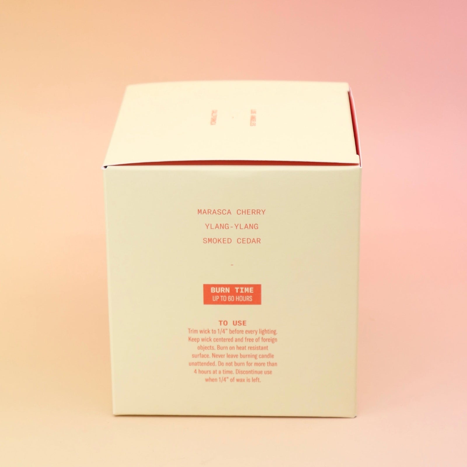 The side of the Smoked Cherry - HI-FI Soy Wax Candle box on a pink and yellow background.